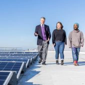 Trienens Institute Co-Executive Director with students on rooftop with solar panels