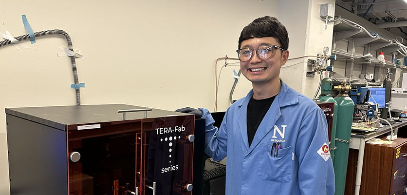 Jinwon Oh next to lab equipment