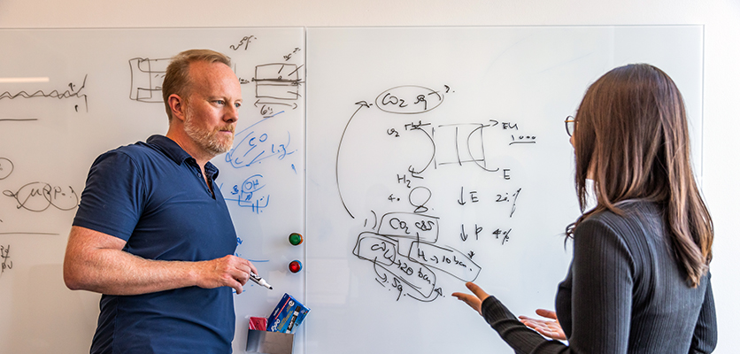 Ted Sargent at a white board with a student