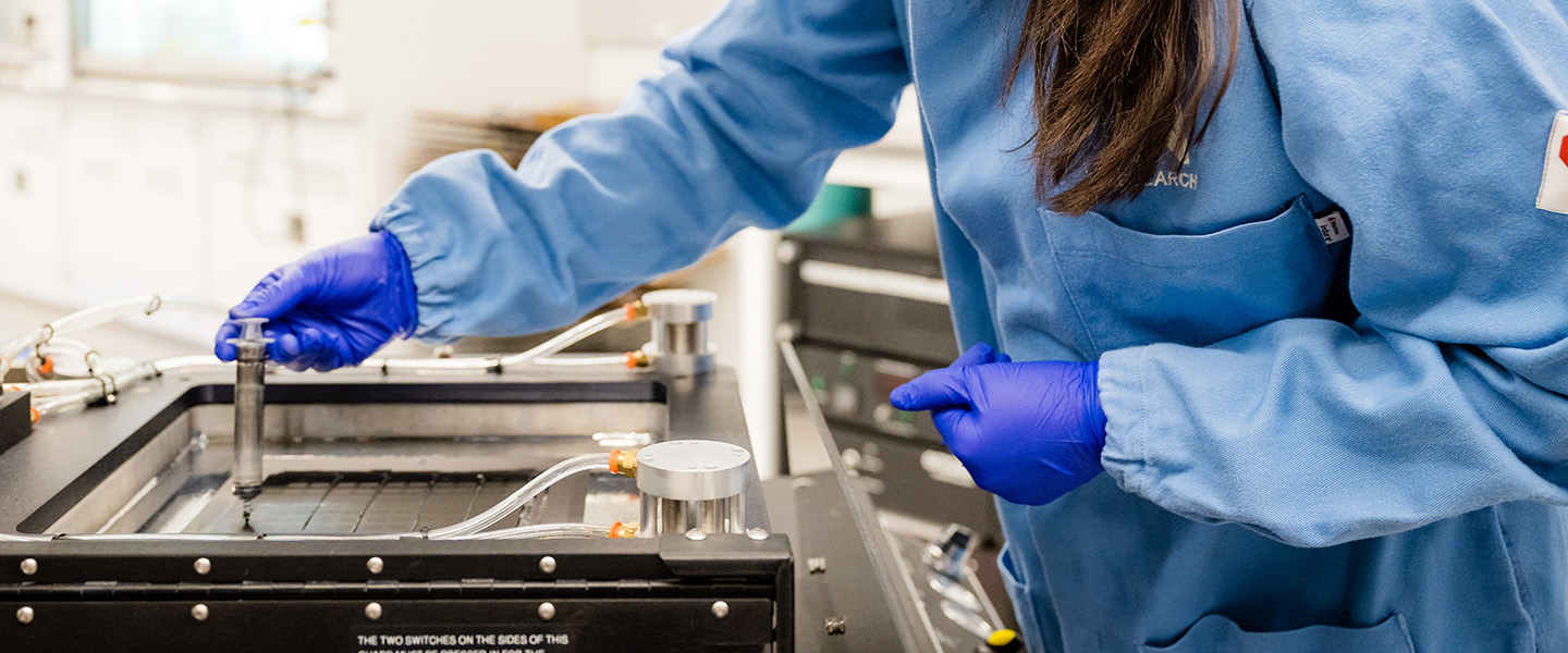 gloved hands working in a lab