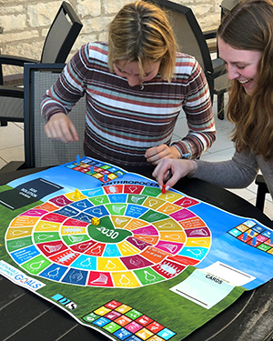 two people sitting at a table enjoying a colorful board game