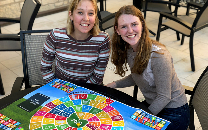 two people sitting together at a boardgame and smiling