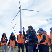 students standing next to windmill